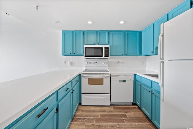 kitchen featuring white appliances, blue cabinets, tasteful backsplash, and dark hardwood / wood-style flooring