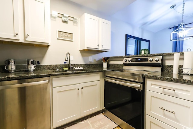 kitchen with appliances with stainless steel finishes, dark stone countertops, white cabinetry, decorative light fixtures, and sink