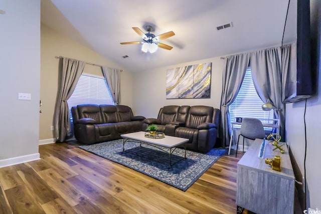 living room with ceiling fan, vaulted ceiling, plenty of natural light, and hardwood / wood-style floors