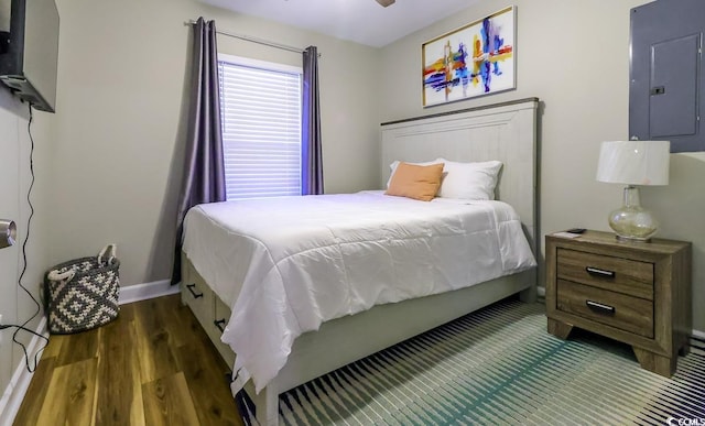 bedroom with dark hardwood / wood-style floors, electric panel, and ceiling fan