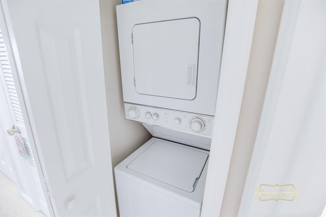 clothes washing area with stacked washer and clothes dryer