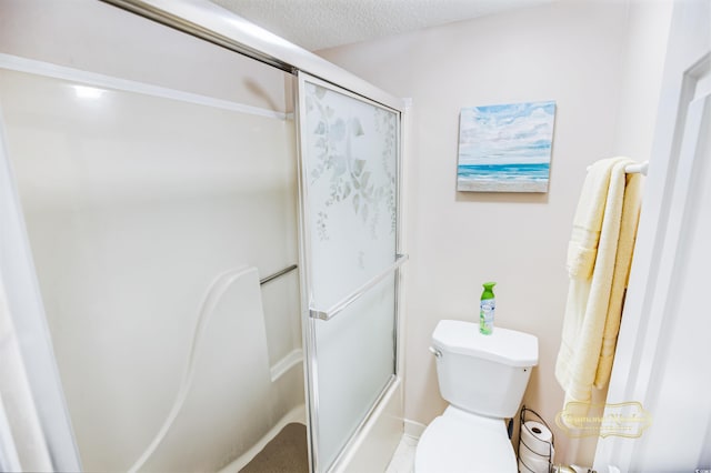 bathroom with a textured ceiling, shower / bath combination with glass door, and toilet