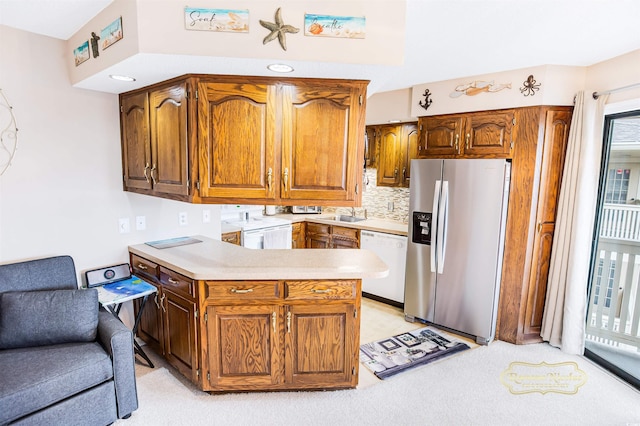 kitchen with white dishwasher, washer / clothes dryer, a healthy amount of sunlight, and stainless steel fridge