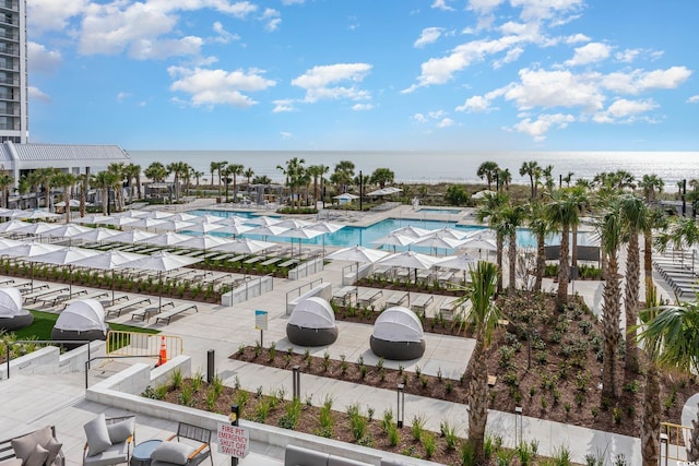 view of swimming pool featuring a water view and a patio area