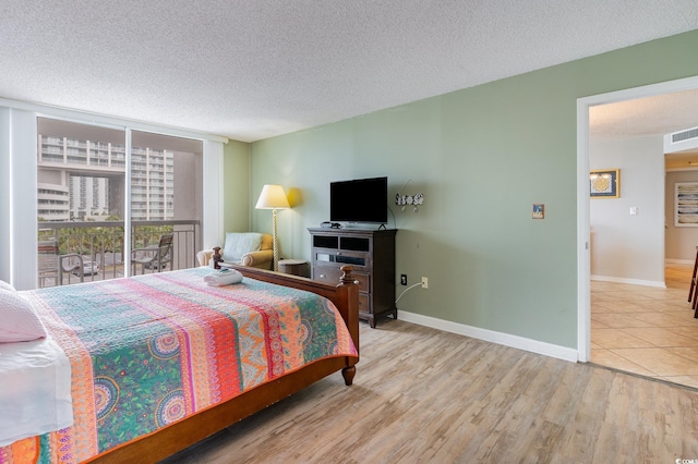 bedroom with light wood-type flooring and a textured ceiling