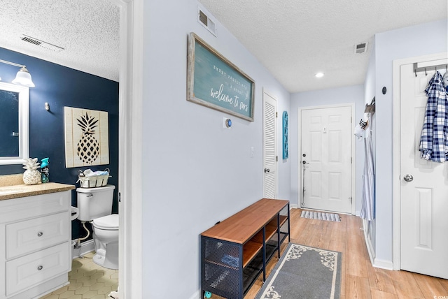 foyer with a textured ceiling and light wood-type flooring