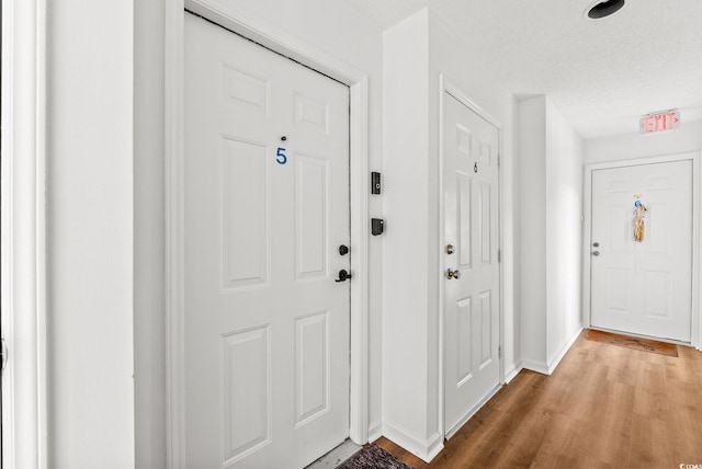 foyer entrance with a textured ceiling and hardwood / wood-style flooring