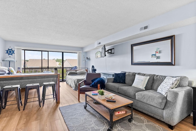 living room featuring light hardwood / wood-style flooring and a textured ceiling