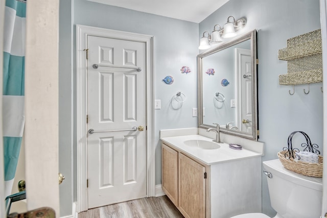 bathroom featuring vanity, hardwood / wood-style floors, and toilet