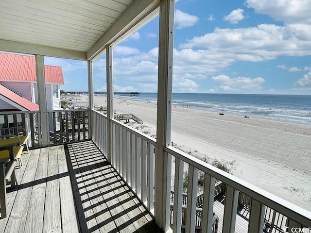 balcony featuring a water view and a view of the beach