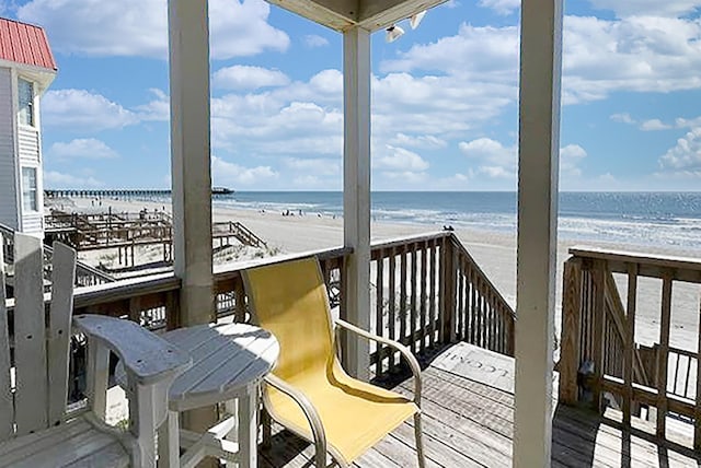 deck featuring a water view and a beach view