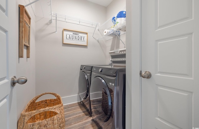 clothes washing area with washer and clothes dryer and hardwood / wood-style floors