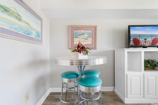 dining space with a textured ceiling and hardwood / wood-style flooring