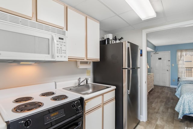 kitchen with light hardwood / wood-style flooring, white cabinets, white appliances, and sink