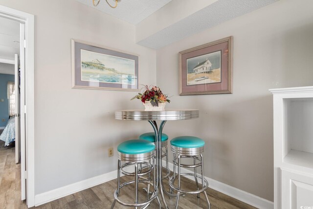 dining area with hardwood / wood-style flooring and a textured ceiling