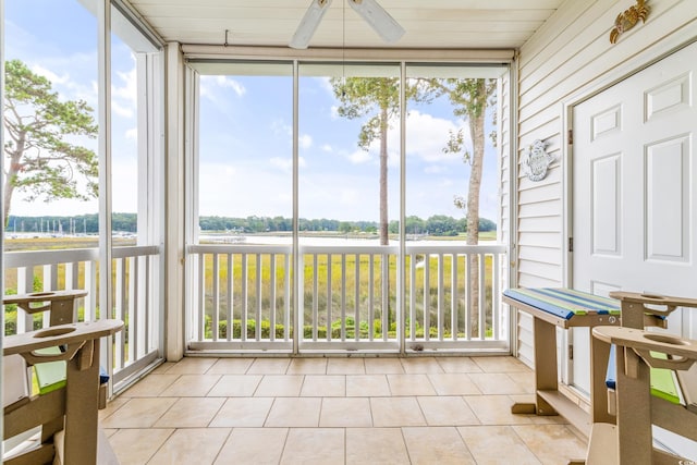 sunroom / solarium with a water view and ceiling fan