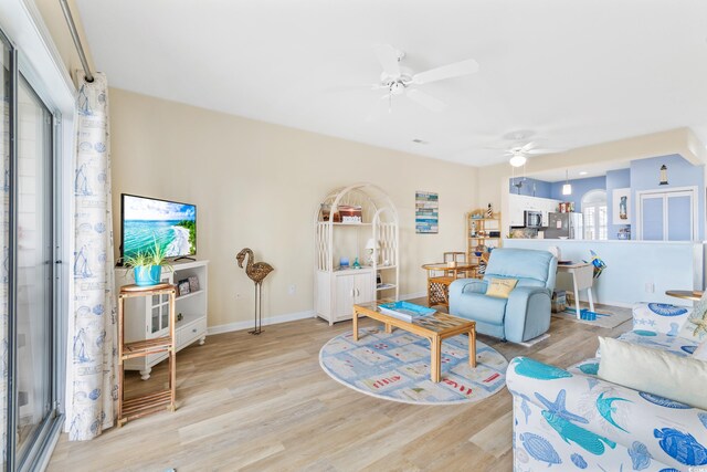 living room with light hardwood / wood-style floors and ceiling fan