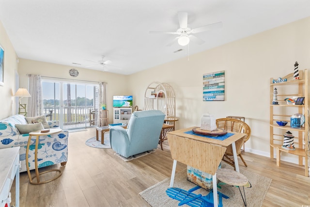 living room with ceiling fan and light hardwood / wood-style flooring