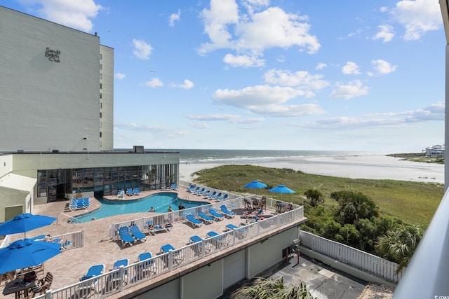 exterior space with a water view, a patio area, fence, and a beach view