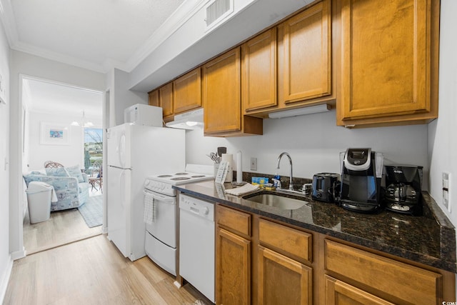 kitchen featuring white appliances, visible vents, dark stone countertops, under cabinet range hood, and a sink