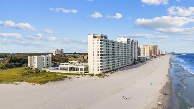 drone / aerial view featuring a view of city, a beach view, and a water view