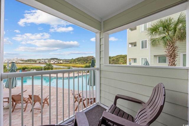 balcony featuring a water view and a view of the beach