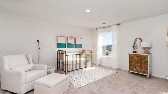 carpeted bedroom with a nursery area