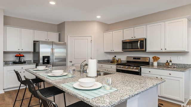 kitchen with sink, stainless steel appliances, dark hardwood / wood-style floors, an island with sink, and white cabinets