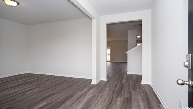 empty room with dark hardwood / wood-style flooring