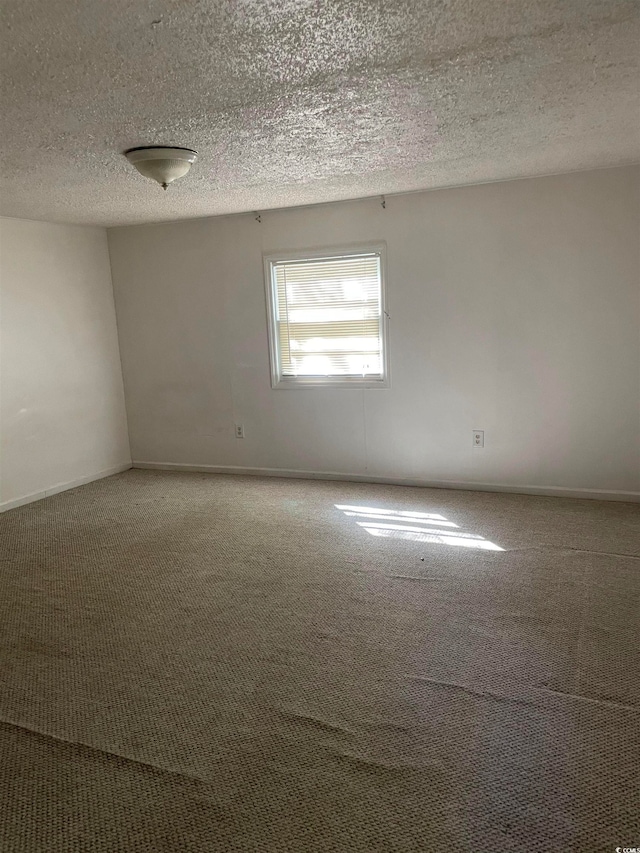 carpeted spare room featuring a textured ceiling