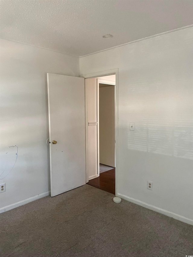 carpeted spare room featuring a textured ceiling