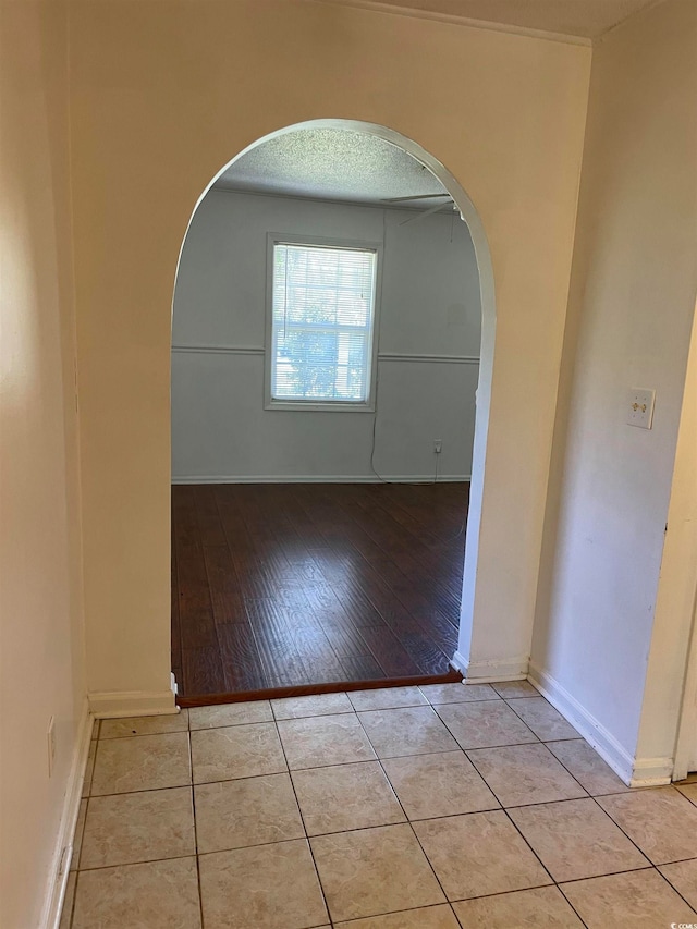 empty room featuring light wood-type flooring and a textured ceiling