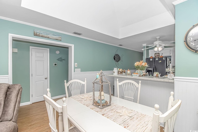 dining space with crown molding, light hardwood / wood-style floors, and ceiling fan