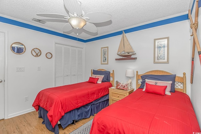 bedroom featuring a closet, ceiling fan, wood-type flooring, and a textured ceiling