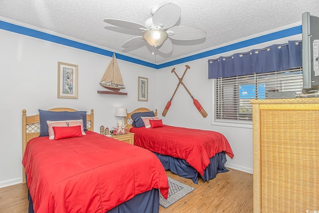 bedroom with crown molding, wood-type flooring, a textured ceiling, and ceiling fan