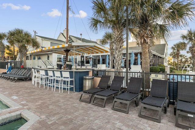 view of patio / terrace featuring a fenced in pool and exterior bar