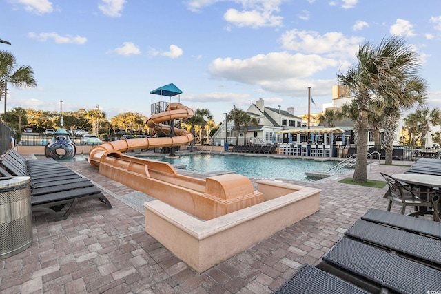 view of pool featuring a water slide and a patio area