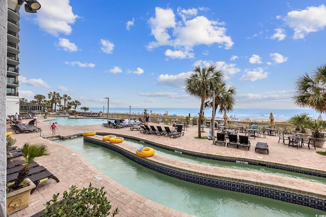 view of pool featuring a patio and a water view