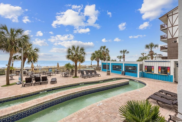 view of swimming pool with a patio and a water view