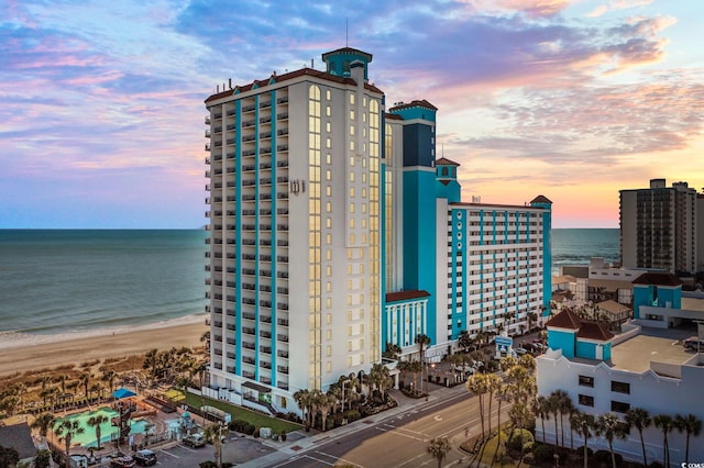 exterior space with a water view and a beach view