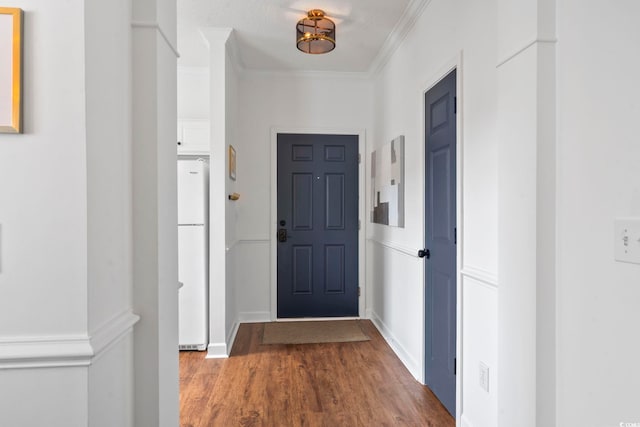 entryway featuring a textured ceiling, wood-type flooring, and crown molding