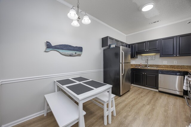 9772 Leyland Dr Unit 9772-9, Myrtle Beach, SC 29572 - kitchen with appliances with stainless steel finishes, a sink, a textured ceiling, crown molding, and light wood-style flooring