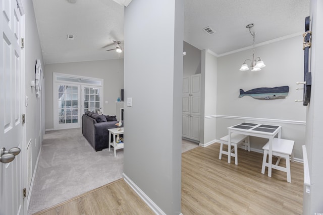 9772 Leyland Dr Unit 9772-9, Myrtle Beach, SC 29572 - corridor featuring light wood-style flooring, a chandelier, lofted ceiling, baseboards, and a textured ceiling