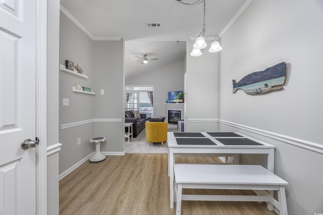 9772 Leyland Dr Unit 9772-9, Myrtle Beach, SC 29572 - dining space featuring ornamental molding, ceiling fan, wood finished floors, baseboards, and a glass covered fireplace