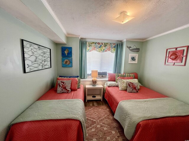 bedroom featuring a textured ceiling, ornamental molding, and wood finished floors