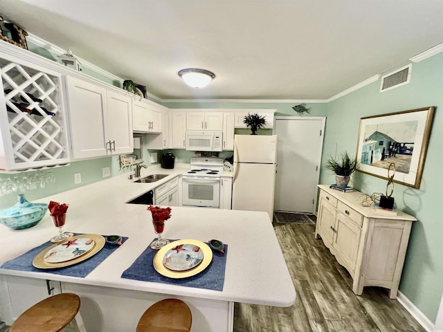 kitchen featuring light countertops, visible vents, crown molding, white appliances, and a sink