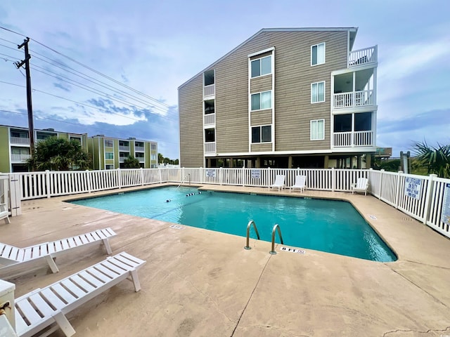 pool featuring fence and a patio