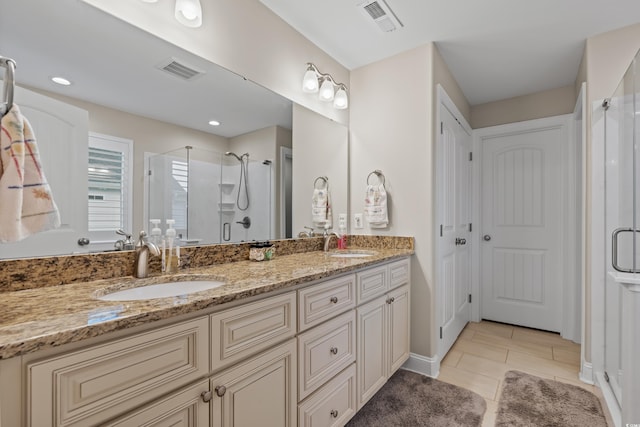 bathroom featuring tile patterned flooring, vanity, and a shower with shower door