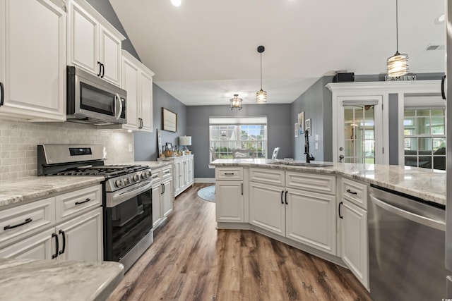 kitchen featuring stainless steel appliances, decorative light fixtures, sink, and white cabinetry