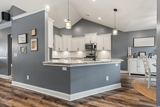 kitchen featuring white cabinets, stainless steel appliances, pendant lighting, and dark wood-type flooring